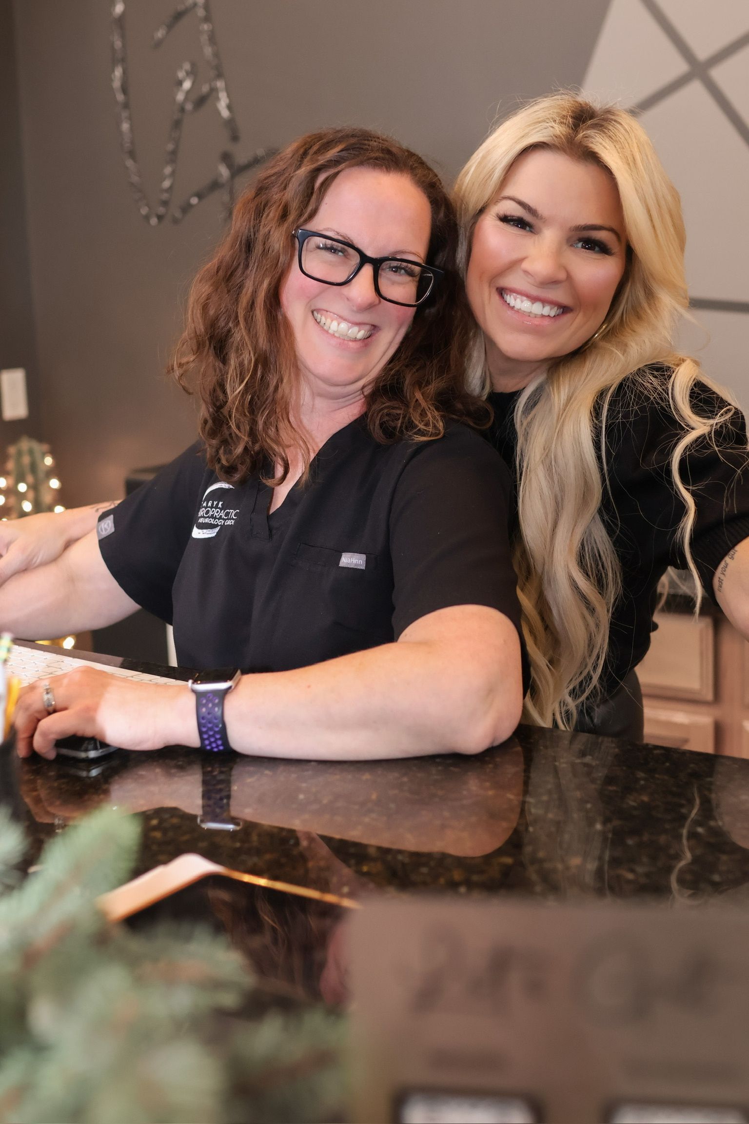Two smiling staff members behind the front desk
