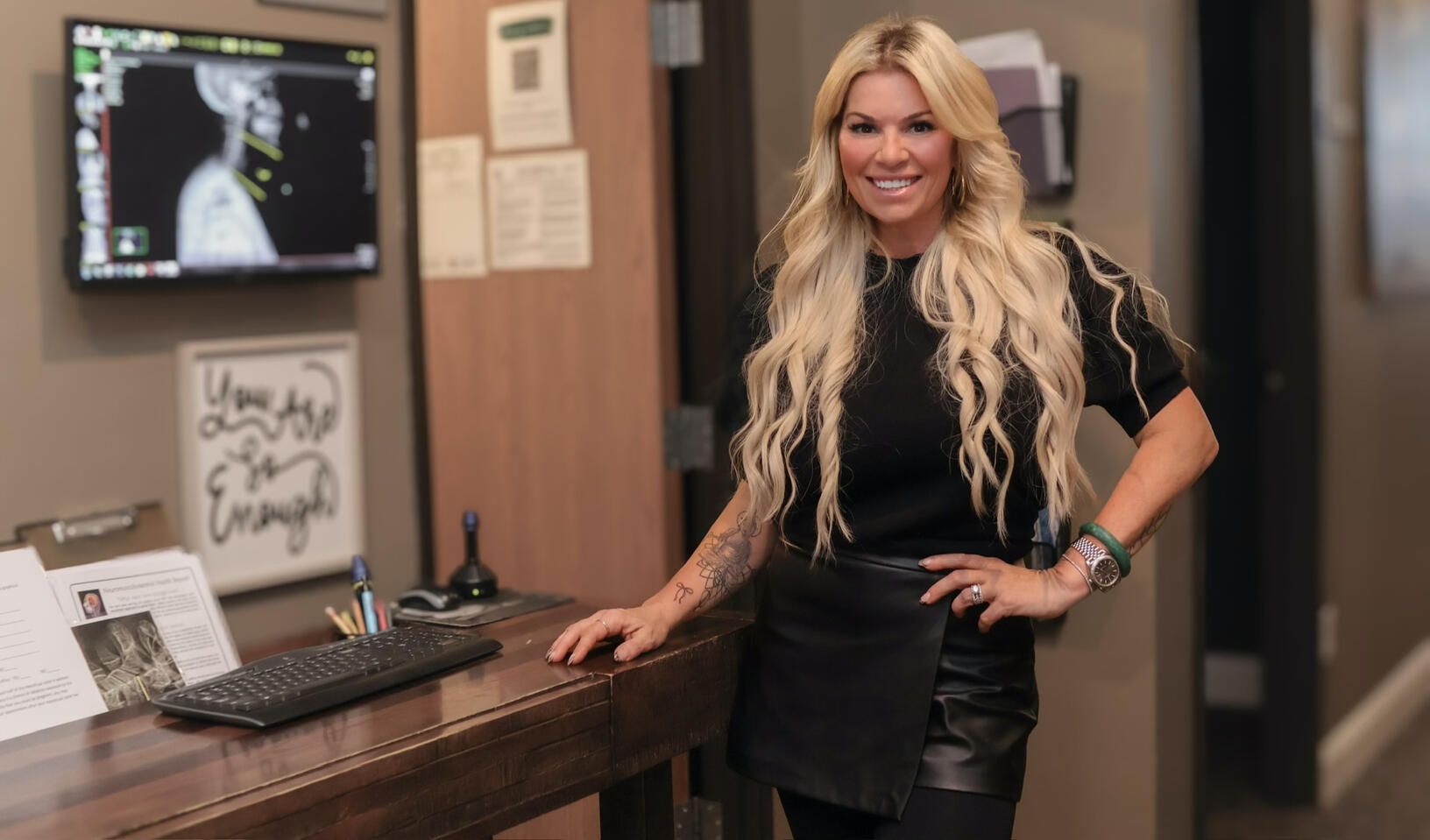 Dr. Christine Hanczaryk standing at the front desk, a digital x-ray on the screen behind her