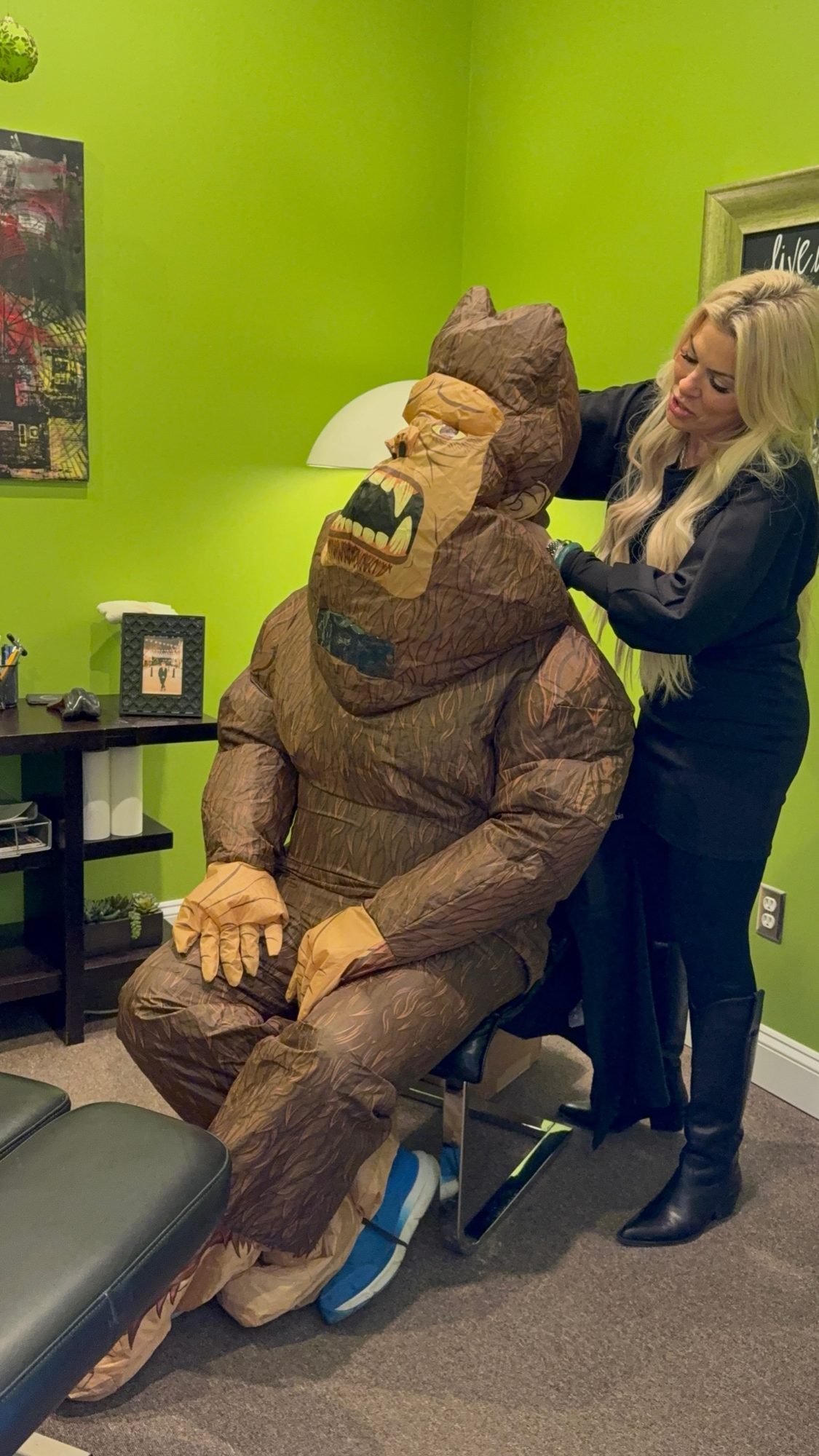 Dr. Christine adjusting the office Bigfoot statue in the green room