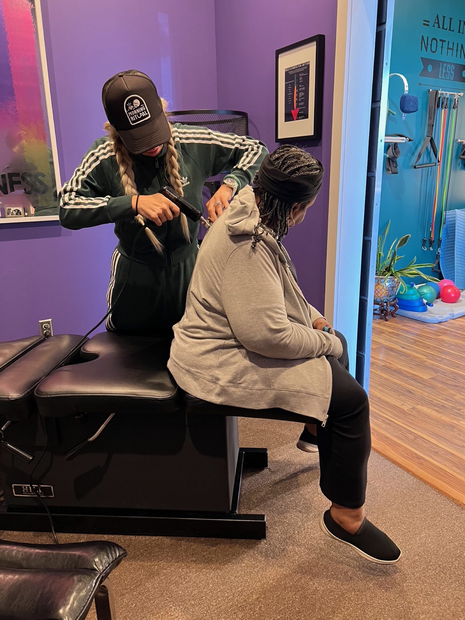 A seated adjustment in the teal therapy room