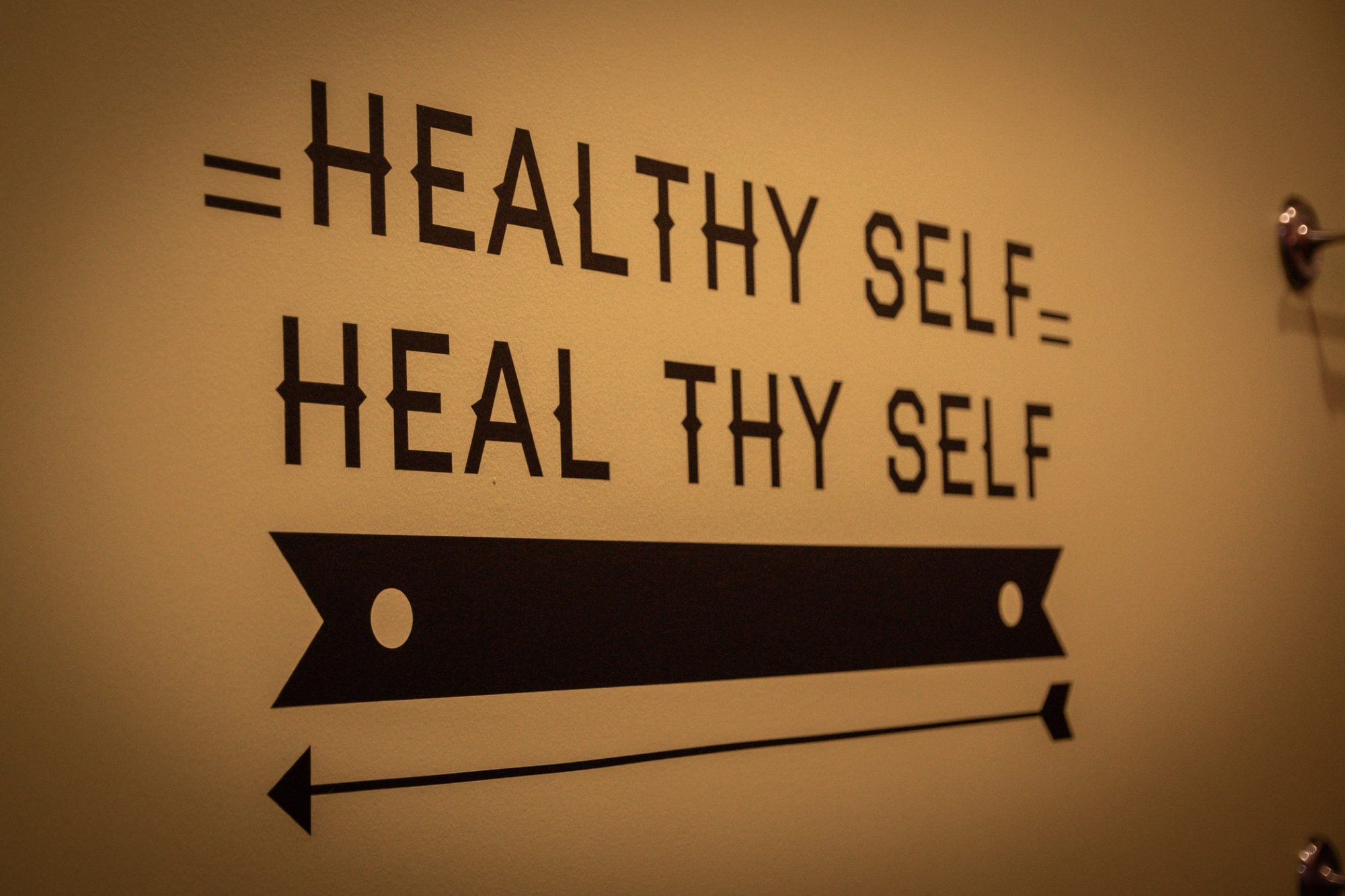 The Healthy Self Heal Thy Self sign under warm light