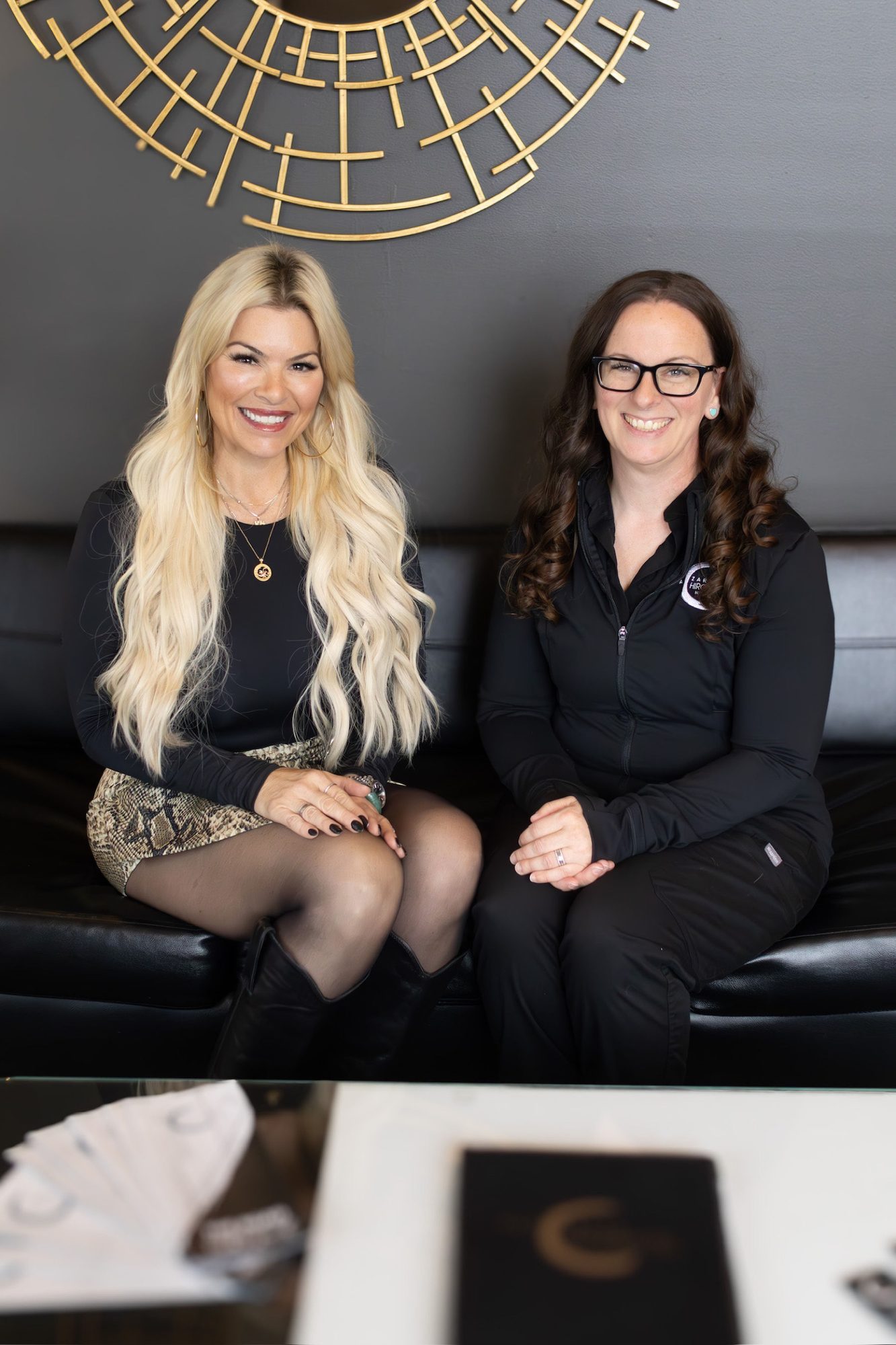 Dr. Christine and Kelli on the black leather sofa