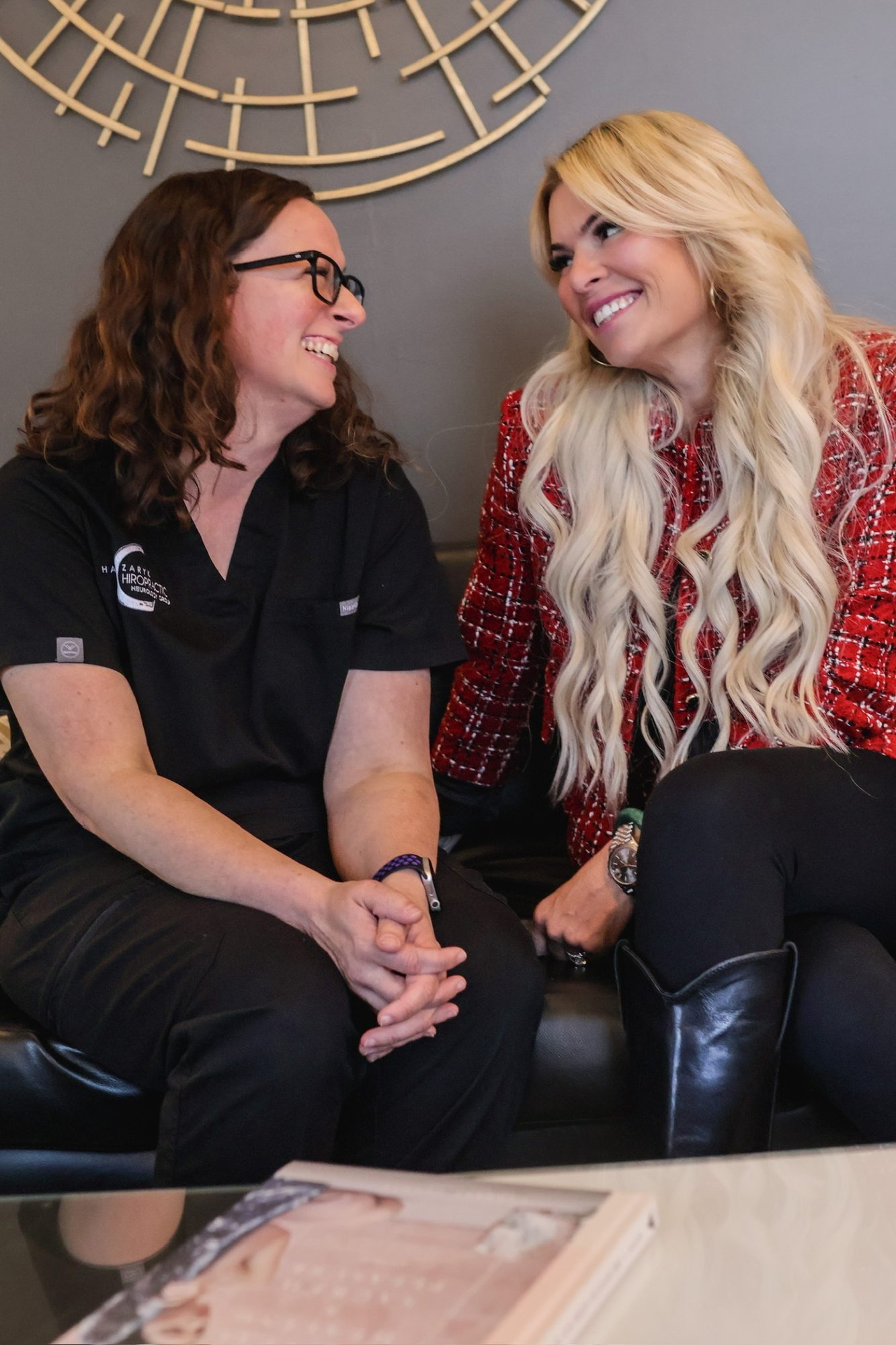 Kelli and Dr. Christine laughing together on the sofa